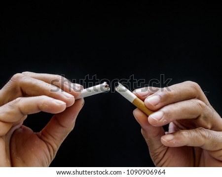 Male hand crushing cigarette on black background, Concept Quitting smoking,World No Tobacco Day.