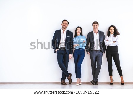 The business people standing on the white wall background Royalty-Free Stock Photo #1090916522