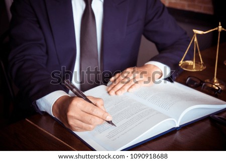 Justice and law concept. Working with document law books, report the case on table in modern office.

