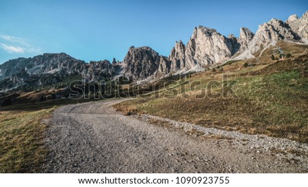 Dirt road and hiking trail track in Dolomites mountain, Italy, in front of Pizes de Cir Ridge mountain ranges in Bolzano, South Tyrol, Northwestern Dolomites, Italy. Royalty-Free Stock Photo #1090923755