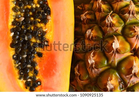 Papaya and pineapple tropical fruits background texture close up.Selective focus.