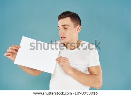 man is looking at a sheet of paper in his hand                           