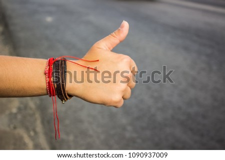 hitchhiking hand sign on the road