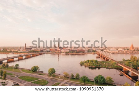 Beautiful aerial view of the Riga old town by the river Daugava and bridges over it. Panoramic Riga scene during sunset.