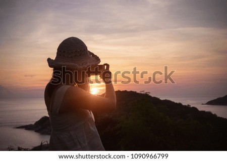 female traveler photographing mountain and sea by cell phone. travel and summer concept.