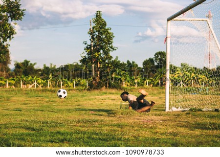 Action picture with copy space of young boy playing soccer football as a goal keeper which is good exercise activity to learn the rules and team work for kids.