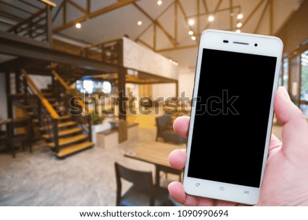 Man use Smartphone blurred images in coffee shop like the background.