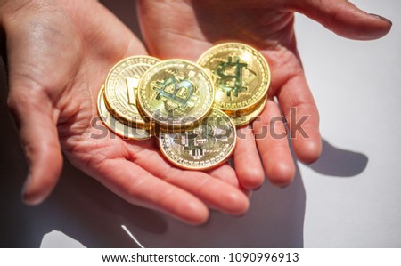 Golden Bitcoin coins in hand, natural sunlight