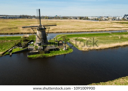 Windmills and water canal in Kinderdijk in a beautiful spring day from air view, Holland