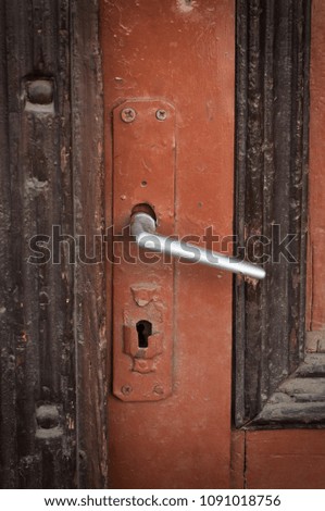 Close-up view of Old vintage, brown wood door with a metallic door knob
