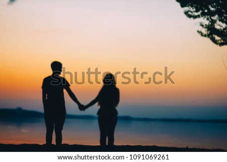 Blurred background of friends at sunset by the sea. boy and girl .