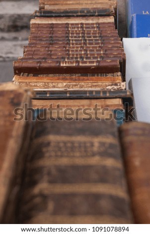 Antique brown books selling at an antique market along a street