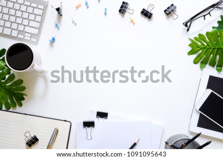 Office desk computer keyboard, coffee cup, notebook paper, tablet, smartphone and document paper top view workspace.