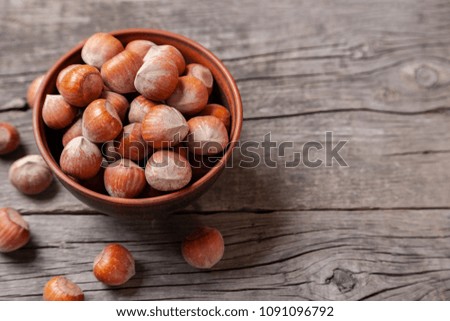 Hazelnut to plate on an old wooden table.. Copy space for text