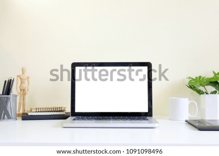 Workspace with laptop computer on white table and yellow background mockup space.