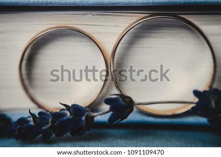Golden wedding rings lie on the books with flowers