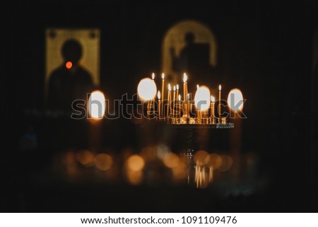 Candles shine in the darkness in the church