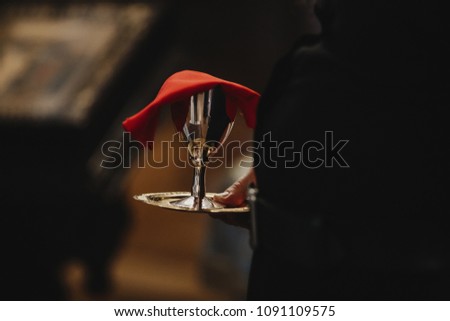 Man holds a goblet with holy wine standing in the church
