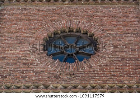 rose window of wood and glass in a brick facade of a church in Madrid. Spain
