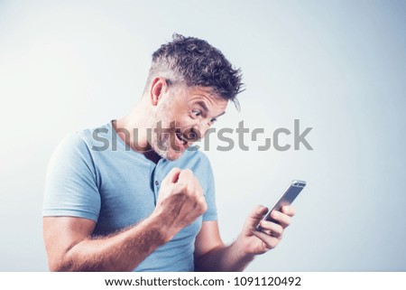 Handsome young man using mobile phone feel happy