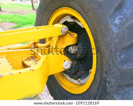 Big rubber tire with heavy equipment in park.