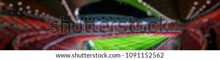 Blurred background of Panorama view of football stadium in match day on beautiful green field with sport light at the stadium.Sports,Athlete,People ,Banner Concept.ArsenalEmirates Stadium.
