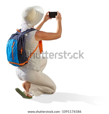 Female, girl, or woman tourist taking photo with phone or cellphone, isolated on white background including clipping path.
