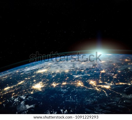 Beautiful Earth space view by night with sun on horizon with copyspace. Science background. Elements of this photo furnished by NASA.