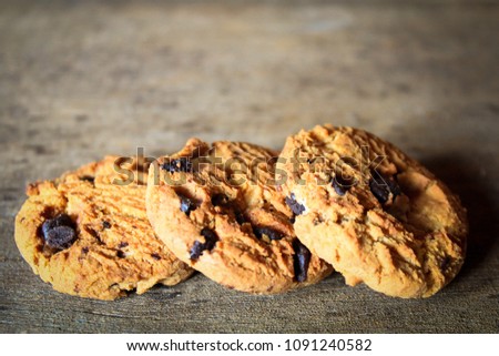 Three cookies stacked on a vintage wooden background.