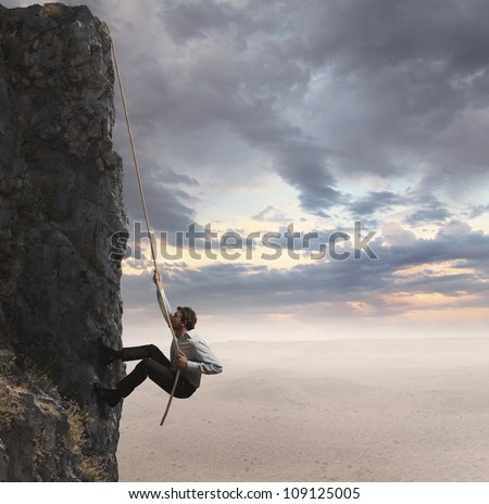 Businessman climbs the mountain. Concept of professional success
