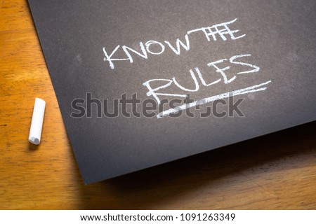 KNOW THE RULES text, handwriting as a note on black paper on the table Royalty-Free Stock Photo #1091263349