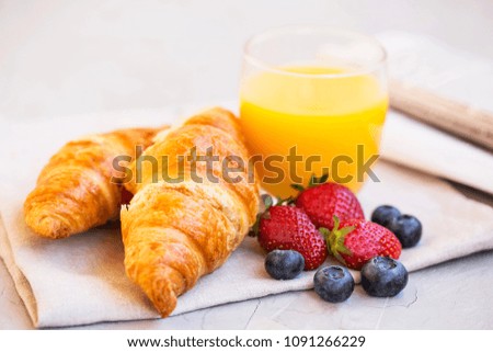 Healthy breakfast with orange juice, croissants and berries