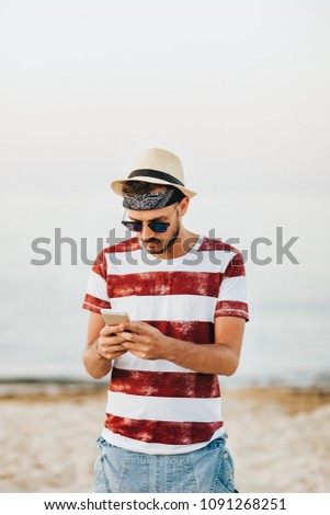 Young man at the beach using mobile phone