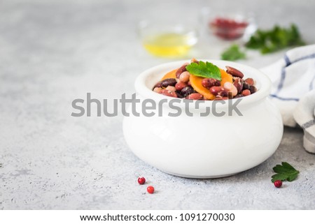 Tuscan beans in a pot on concrete background. Selective focus, space for text. 