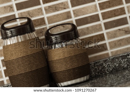 Rope wrapped decorative glass jars on brown background