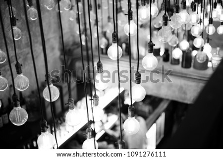 Black and white picture of vintage bulbs which are hanging on the ceiling.