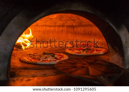 Original neapolitan pizza margherita in a traditional wood oven in Naples restaurant, Italy Royalty-Free Stock Photo #1091295605