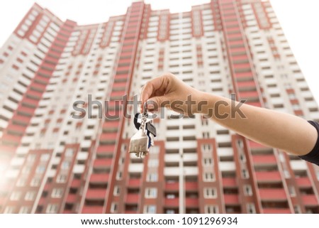 Closeup photo of young woman showing keys from new apartment. Concept of real estate investment