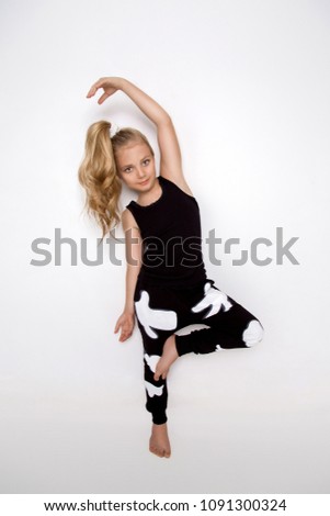 Cute blonde little girl in sport outfit on a white background in studio.