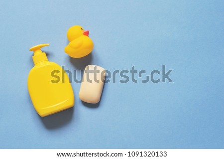 Yellow liquid soap package, rubber duck on a blue background. Flat lay photo baby bath products. Mockup for beauty blog or web site