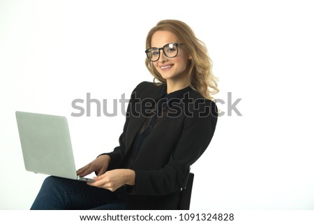 beautiful young girl with glasses in a black suit with a laptop on a white background