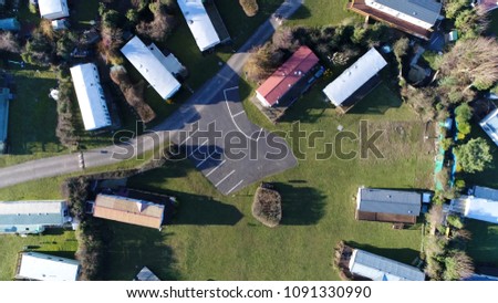 Aerial top down view picture of Farm Campsite and Holiday Park moving left over site showing the long-term campsite that includes permanent and semi-permanent setups and parking spaces