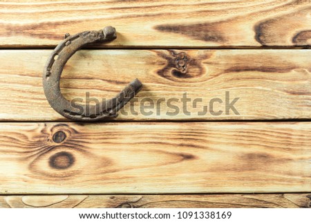 old rusty horseshoes on wooden board