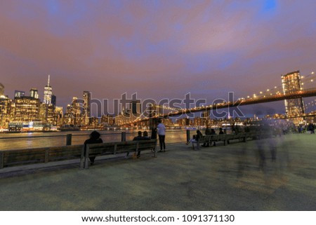 Brooklyn Bridge over hudson river in New York City at sunset.