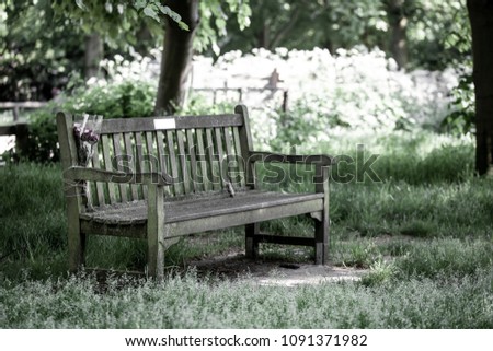 Memorail Bench in the Park with flower bouquet tied on with string