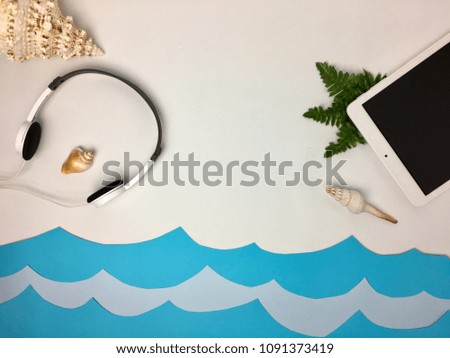 Beach scene with tablet and earphones.