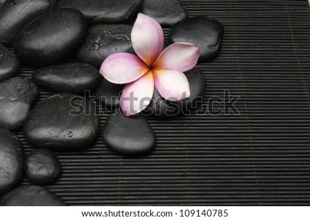 Pile of zen stones with frangipani on mat