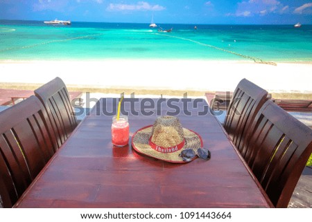 Group of gadgets travel icons for relax time fresh watermelon smoothie,hat of thailand and sunglass on wooden table with nice clear blue sky sea and sand on lipe beach thailand for nature background.