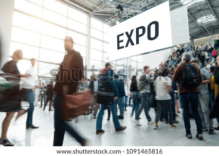 blurred people at a trade fair entrance