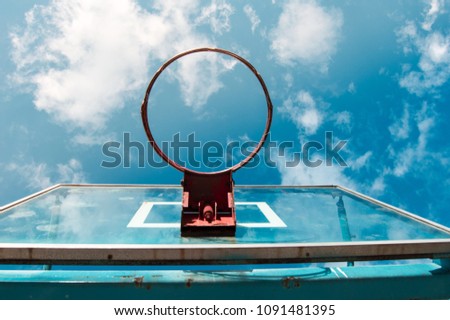 Perspective view of a bright blue turquoise and red basketball backboard background with a beautiful sky